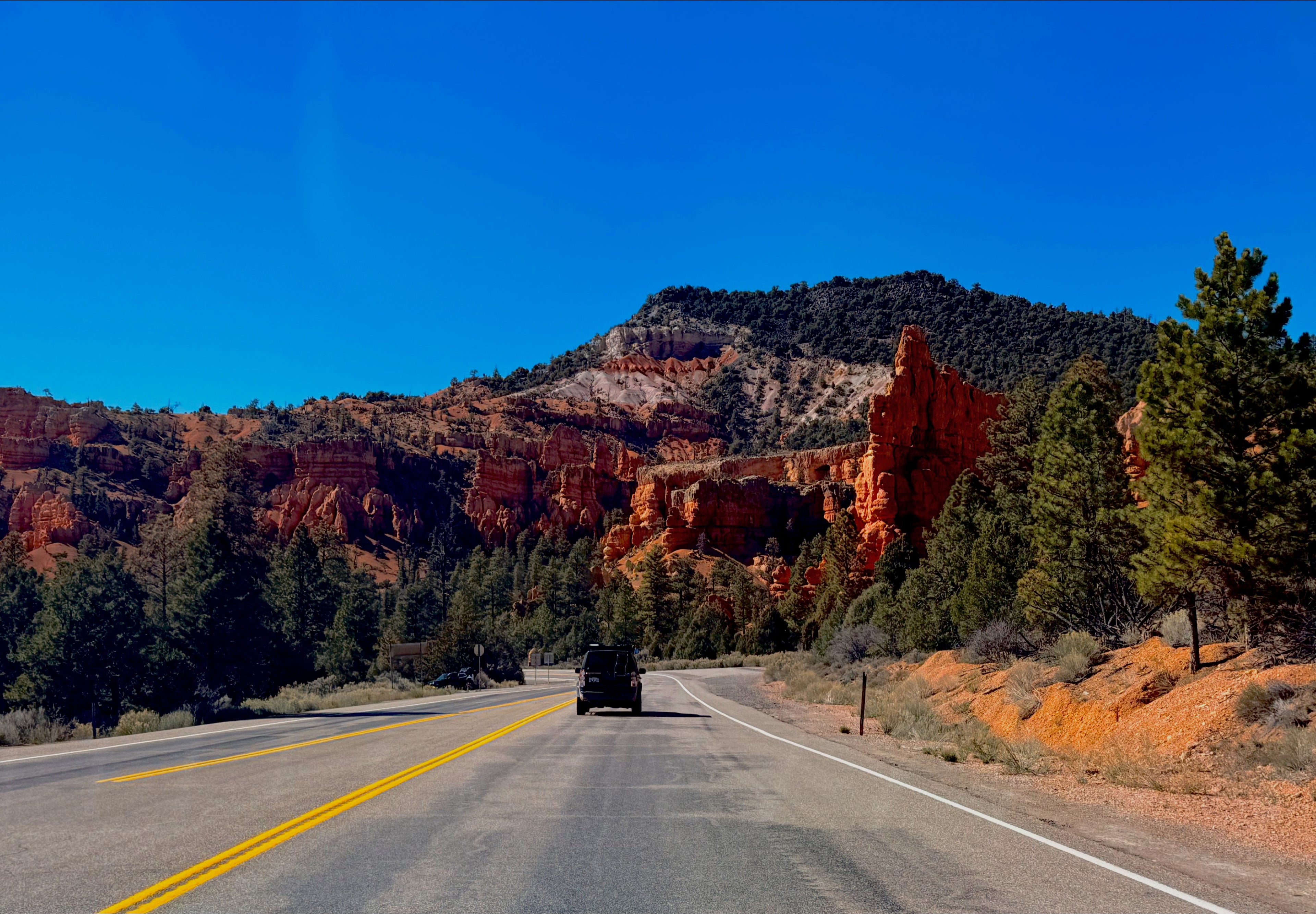 Scenic road with red rock formations and clear blue sky